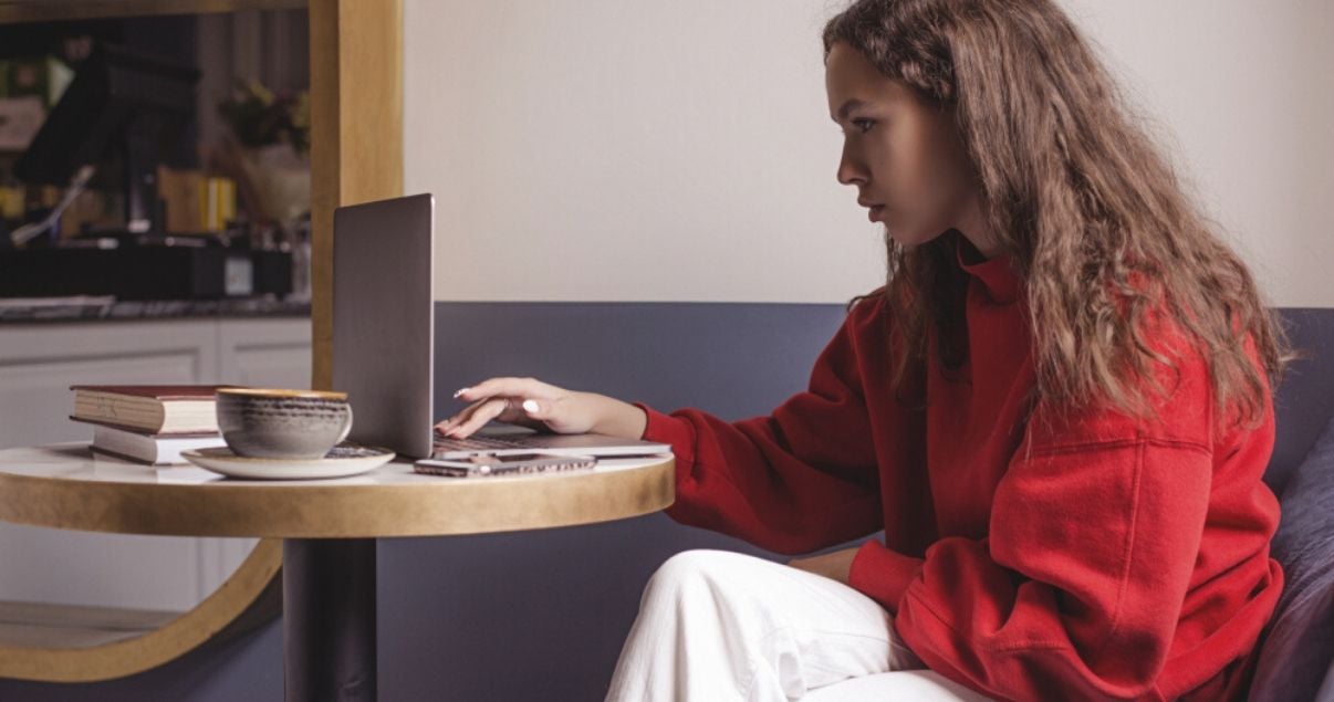 Mujero joven con pelo largo estudiando comparativos y superlativos en ingles en una computadora