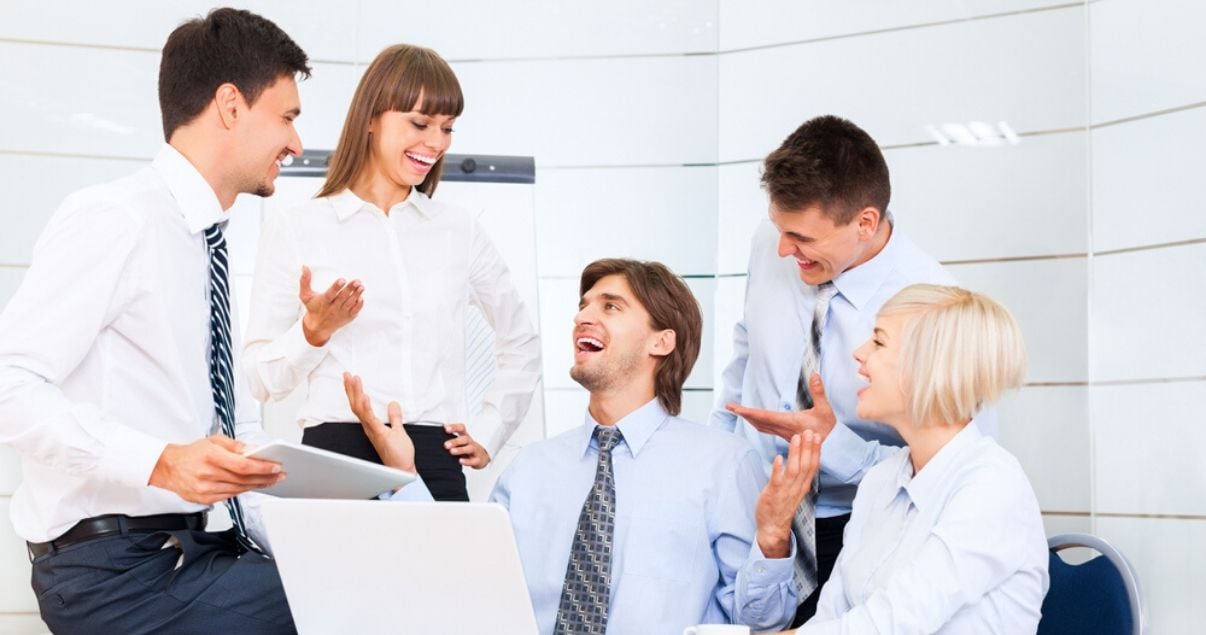 Ejecutivos y empleados de una importante empresa en un buen clima organizacional conversando y riendo luego de capacitarse en inglés con Wall Street English