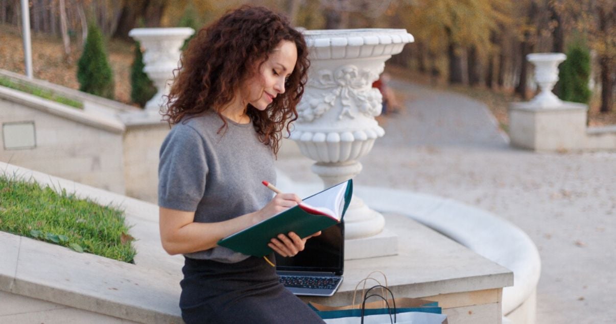 Mujero joven con rulos leyendo al aire libre sobre el presente perfecto en inglés