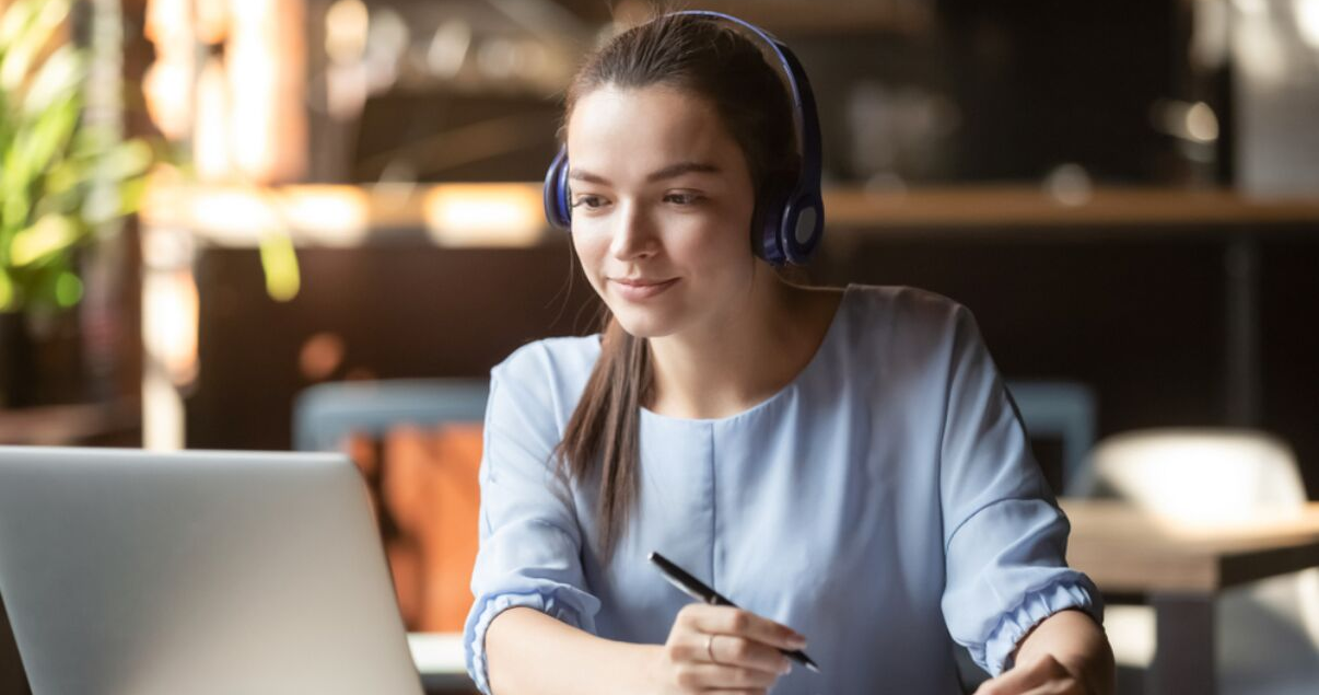 mujer joven con laptop y auriculares para aprender inglés desde su casa