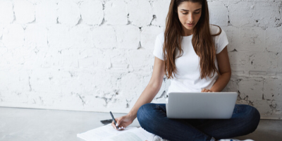 mujer joven con laptop tomando clases online para hablar inglés con fluidez