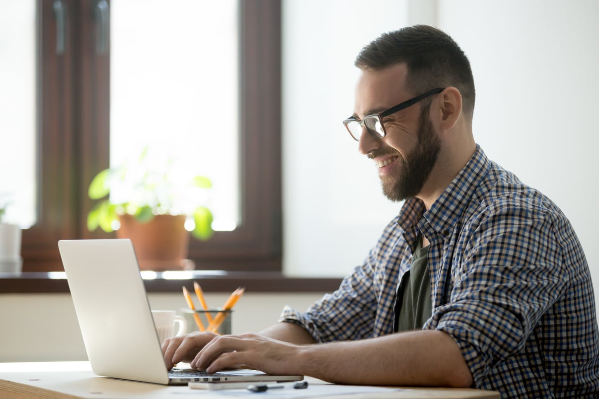 hombre-feliz-escribiendo-correo-positivo-al-cliente