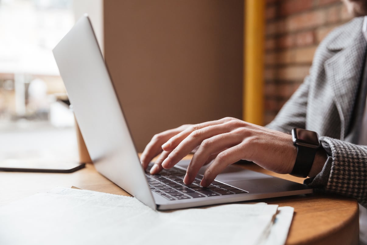 imagen-recortada-empresario-anteojos-sentado-junto-mesa-cafeteria-usando-computadora-portatil
