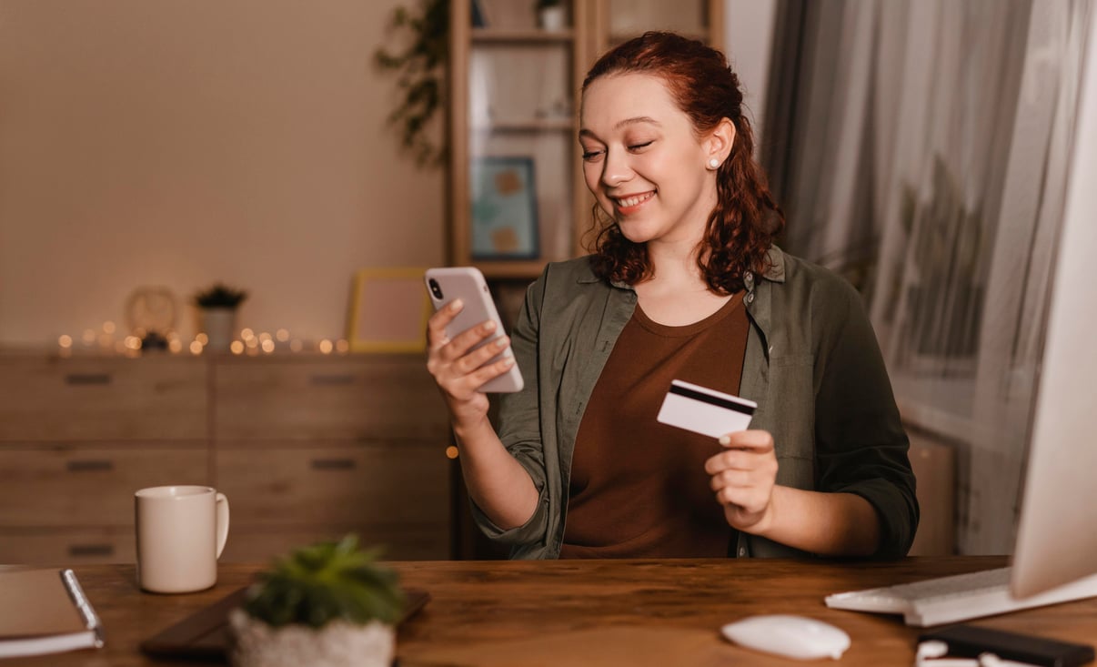mujer-sonriente-su-telefono-inteligente-casa-tarjeta-credito