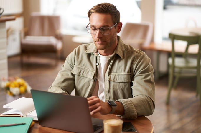 remote-work-freelance-concept-handsome-man-glasses-sits-with-notebook-laptop-studying