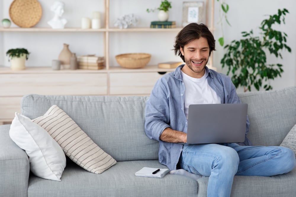 Hombre aprendiedo en su sillon con su laptop a aprender a decir la fecha y hora desde su casa