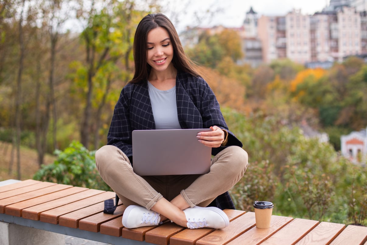 young-beautiful-smiling-casual-woman-working-laptop-city-park