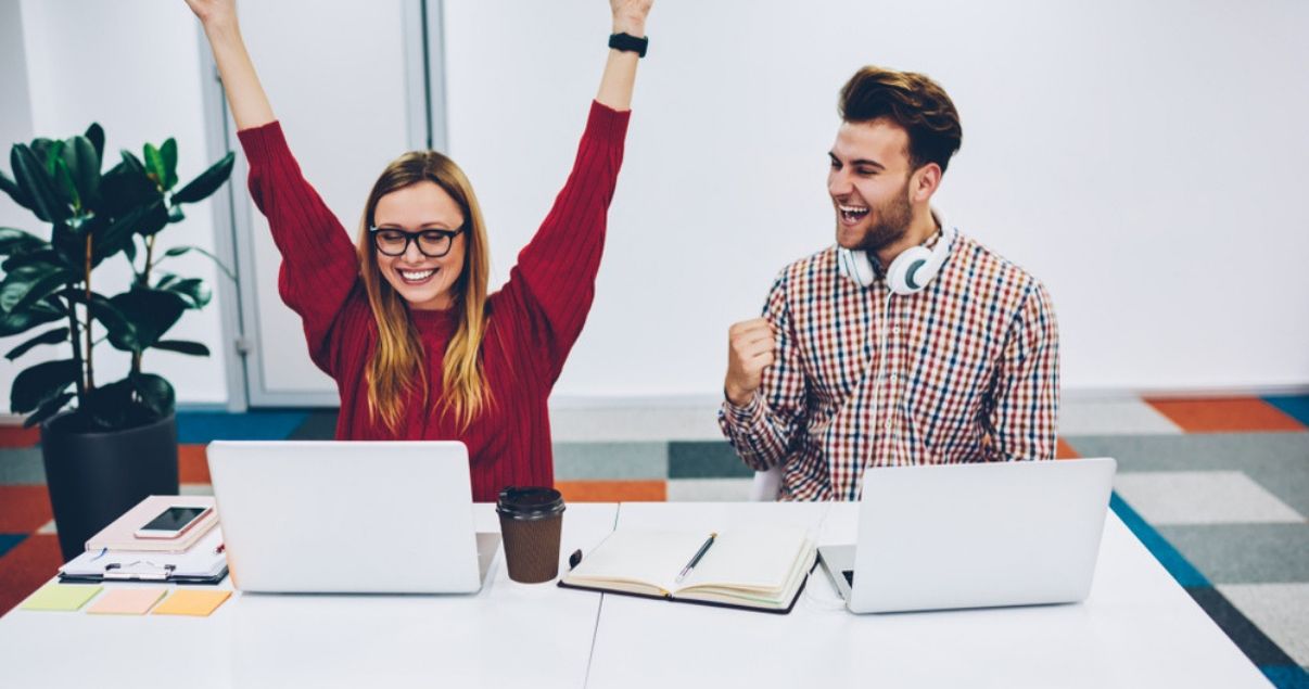 Dos jovenes celebrando y estudiando en su curso de inglés creando un buen ambiente de estudio.